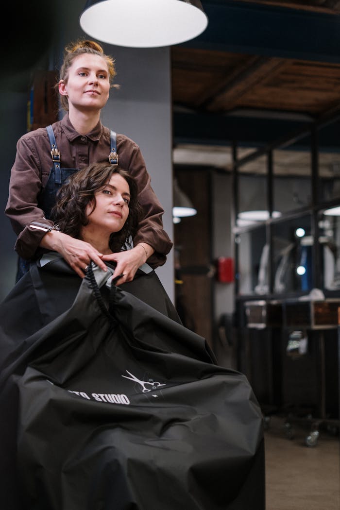 A stylist prepares a client's hair in a modern salon setting, showcasing the art of professional hairstyling.